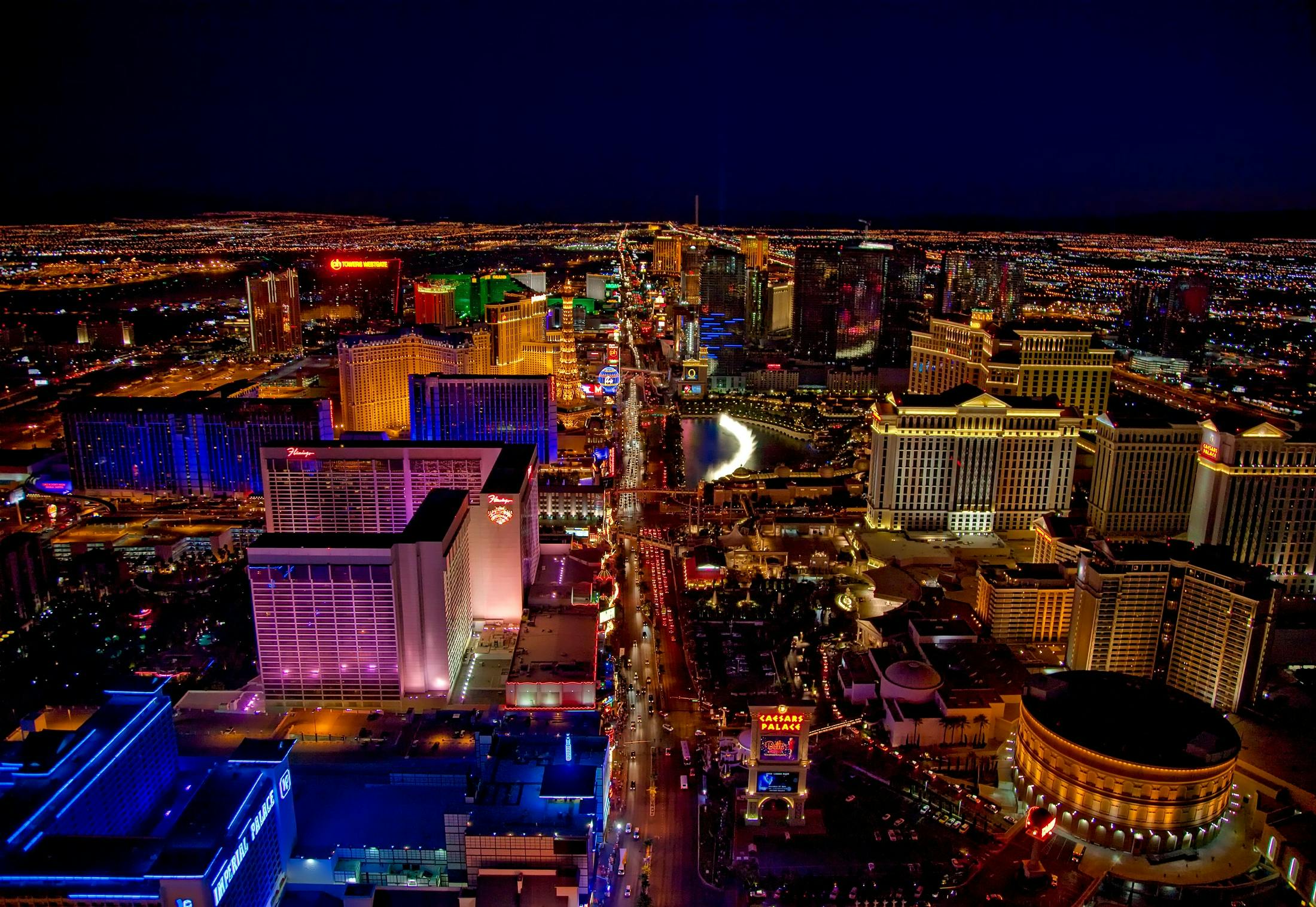 limoz app view of Las Vegas Strip glowing at night with vibrant neon lights and bustling nightlife.